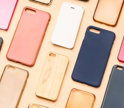 Pile of multicolored plastic back covers for mobile phone. Choice of smart phone protector accessories on neutral background. A lot of silicone phone backs or skins next to each other